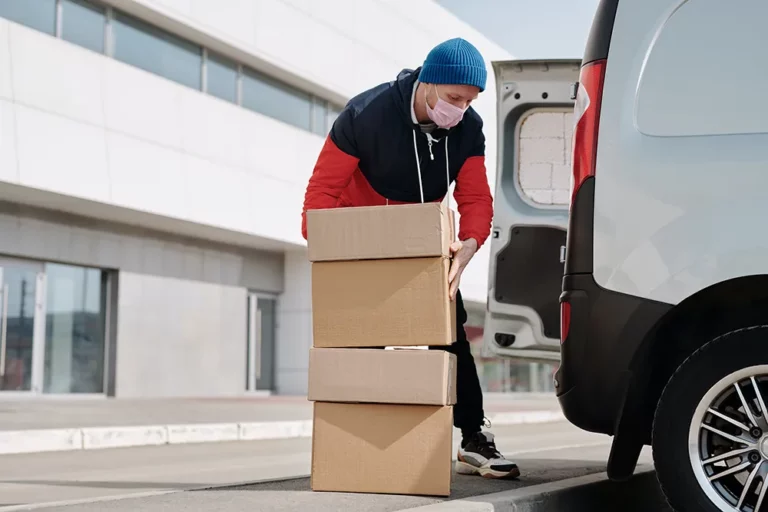 Ein Mann legt Kartons in einen Lieferwagen.